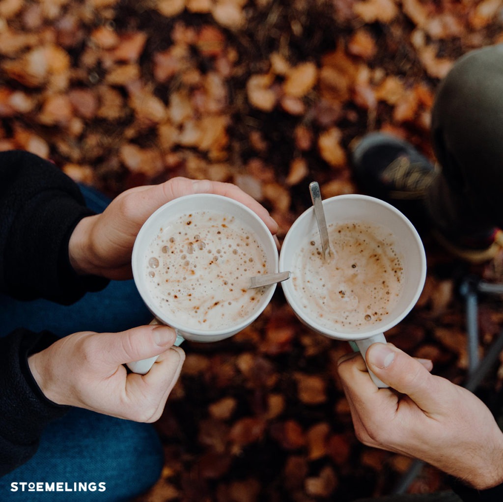 Deux clients stoemelings qui boivent une tasse de café dans un bois lors d'un trip en tente de toit