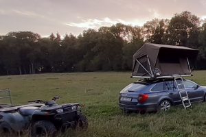 tente de toit dans prairie avec quad