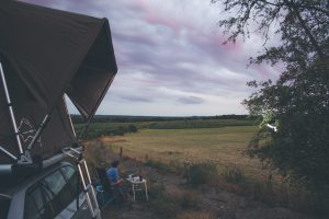 coucher de soleil sur champs avec tente de toit jimba