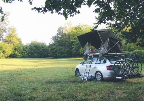 tente de toit stoemelings avec accessoire porte-vélo thule dans une prairie